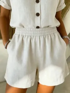 Close-up of casual off-white cotton linen shorts featuring an elastic waist and side pockets