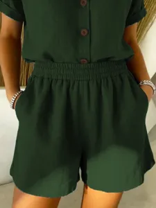 Close-up of dark green women's cotton linen shorts featuring elastic waist and pockets