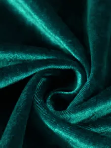Macro shot of premium teal velvet fabric texture showing soft pleats and sheen