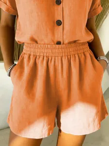 Detail of orange linen-cotton shorts with elastic waist and side pockets for women