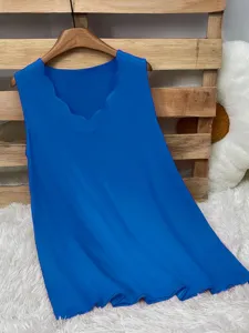 Close-up of vibrant blue sleeveless vest featuring a unique scalloped V-neckline design