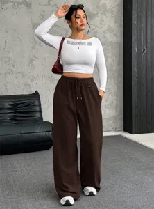 Model wearing white long-sleeve crop top and brown drawstring wide-leg casual pants