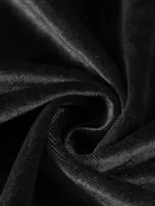 Close-up macro view of black velvet pleated fabric with elegant spiral texture detail