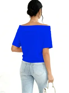 Rear view of a vibrant royal blue off-the-shoulder top styled with light denim jeans