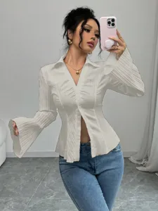 Mirror selfie of a model wearing an elegant white V-neck striped blouse with flared sleeves