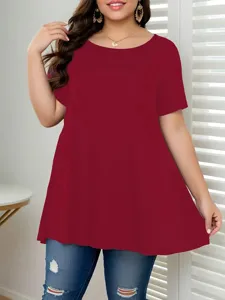 Plus-Size-Frau in burgunderfarbenem Kurzarm-T-Shirt mit Rundhalsausschnitt und zerrissenen Jeans