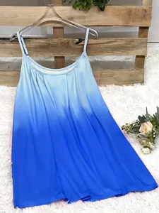 Blue ombre pleated camisole with thin straps shown against a rustic wooden background