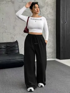 Stylish women's black wide-leg drawstring pants paired with a white long sleeve crop top