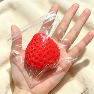 Nahaufnahme eines realistischen Erdbeer-Squishy-Spielzeugs in einer Klarsichtverpackung
