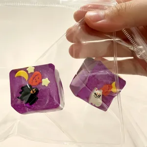 Two purple Halloween squishy toys with ghost and pumpkin designs in a clear plastic bag