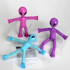 Primer plano de tres juguetes alienígenas de colores con ventosas y extremidades de tubo.