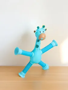 Blaues Giraffen-Teleskop-Spielzeug mit Saugnäpfen auf einer natürlichen Holzoberfläche.