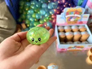 Κοντινό πλάνο πράσινου glitter squishy ψωμιού ατμού με χαριτωμένο πρόσωπο emoji στο χέρι