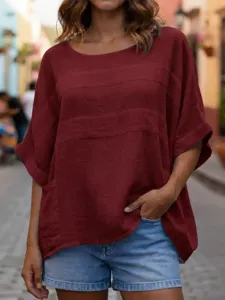 Close-up of a women's casual loose-fit burgundy top with round neck and short sleeves.