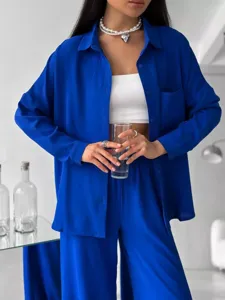 Dettaglio di un elegante set da casa blu reale con camicia oversize e pantaloni larghi.