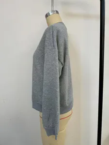 Side profile view of a gray textured quilted sweatshirt with elegant diamond patterns