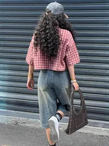 Streetwear style red plaid cropped shirt with denim shorts shown from a back perspective.