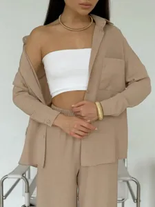 Dettaglio di un set casual con camicia a tinta unita e pantaloni larghi.