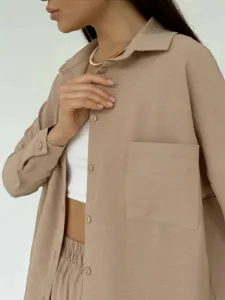 Dettaglio ravvicinato di una camicia beige testurizzata con tasca frontale e bottoni
