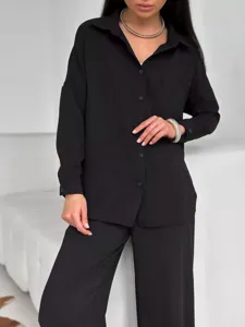 Vista dettagliata di un completo casual nero da donna con camicia e pantaloni larghi.