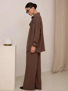 Vista laterale di un set marrone due pezzi con camicia e pantaloni a gamba larga da donna