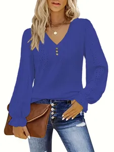 Detail view of the blue eyelet V-neck blouse with button accents and ruffled cuffs.