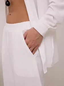 Vista dettagliata della tasca laterale su pantaloni da relax bianchi testurizzati a gamba larga
