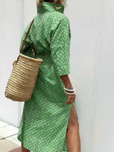 Detail side view of green and white geometric patterned midi shirt dress with side slit