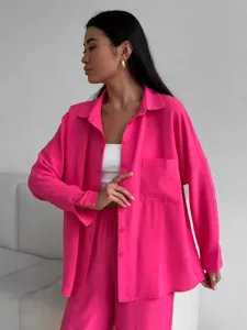 Completo fucsia due pezzi con camicia oversize e pantaloni a gamba larga.