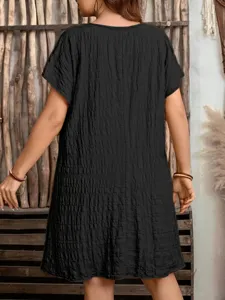 Back view of a black loose-fitting casual dress featuring unique textured crinkle fabric