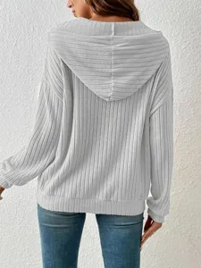 Close-up of the back view of a light grey ribbed hooded sweatshirt showing fabric texture.