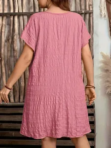Back view showing the fabric texture of this pink loose short sleeve dress in a boho setting