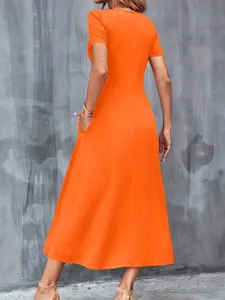 Rear view of a vivid orange short sleeve maxi dress with practical side pockets.