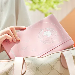 Agenda 2025 rosa con relieves celestiales plateados colocada en un bolso elegante
