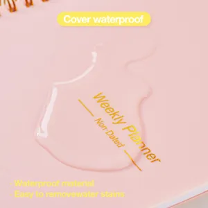 Dettaglio dell'agenda settimanale rosa con copertina impermeabile e gocce d'acqua