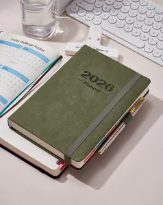 Dettaglio dell'agenda giornaliera 2026 con copertina verde scuro e fascia elastica