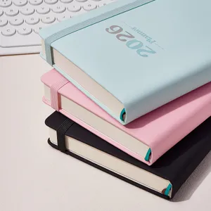Pila di agende 2026 in blu, rosa e nero con dettaglio del cinturino elastico.