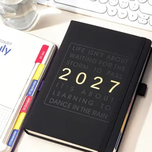 Détail d'un agenda A5 noir 2027 avec une citation inspirante en feuille d'or brillant