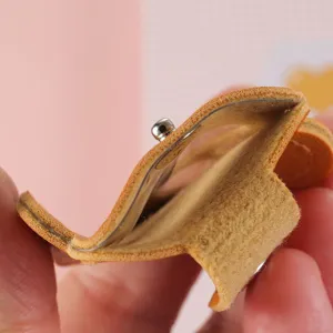 Nahaufnahme des orangefarbenen Leder-Schlüsselanhängers mit einem robusten Metalldruckknopf