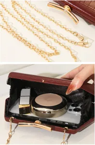 Detail der Abendtasche mit Krokodilmuster zeigt Innenkapazität und goldene Kette