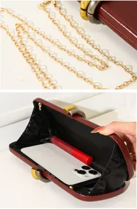 Detalle del bolso de noche de PU con diseño de cocodrilo, cadena dorada y espacio interior