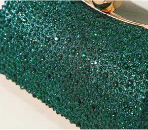 Makro-Detail einer luxuriösen smaragdgrünen Abendtasche mit Strass und Goldrahmen