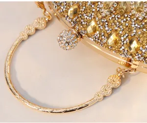 Makro-Detail einer goldenen Abendtasche mit Strasssteinen und geschnitztem Metallgriff