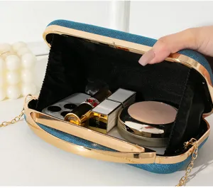 Innenansicht einer eleganten blauen Glitzer-Abendtasche mit goldenem Metallgriff und Kette