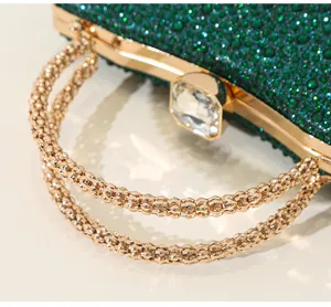 Detail einer luxuriösen grünen Strass-Abendtasche mit goldenem Griff und Kristallverschluss
