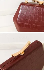 Detailansicht der weinroten Abendtasche mit Krokodilprägung und elegantem goldenen Verschluss.