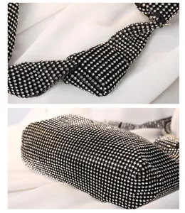 Close-up of shimmering silver rhinestones and knot detail on black evening party handbag.