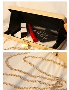 Detailansicht einer luxuriösen goldenen Abendtasche mit Blatt-Verschluss und Metallkette