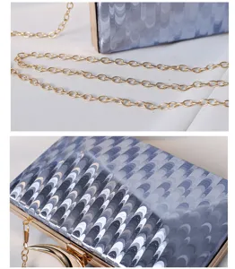Nahaufnahme einer glänzenden blauen PU-Clutch mit goldenem Mondgriff