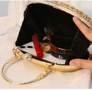 Innenansicht einer goldenen Abendtasche mit Strasssteinen, die Platz für Utensilien zeigt